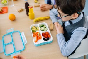 Kind mit Brotdose aus Plastik